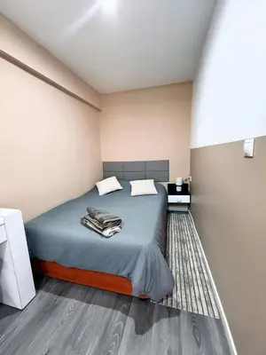 a bedroom with a bed with blue sheets and a rug at Avenue Rooms in Valencia