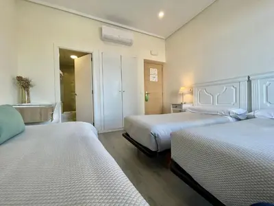 a hotel room with two beds and a bathroom at Balcón Al Mar in Valencia