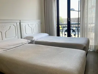 two beds in a hotel room with a balcony at Balcón Al Mar in Valencia