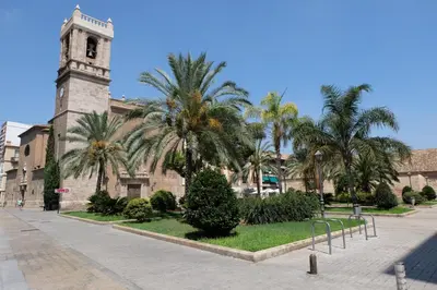 a building with a clock tower and palm trees at Balcón Al Mar in Valencia