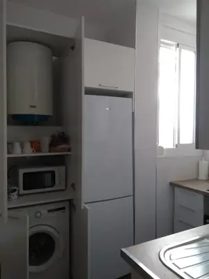 a kitchen with a washing machine and a microwave at Piso céntrico Plaza Toros in Valencia