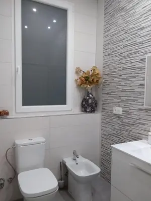 a bathroom with a toilet and a window and a sink at Piso céntrico Plaza Toros in Valencia