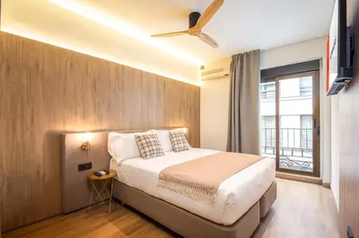 a bedroom with a bed with a ceiling fan at Nommadas Jero - Only Adults in Valencia