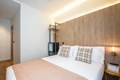 a bedroom with a white bed with a wooden headboard at Nommadas Jero - Only Adults in Valencia