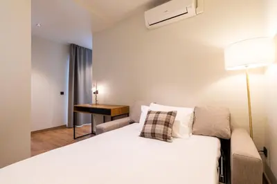 a bedroom with a bed with a lamp and a desk at Nommadas Jero - Only Adults in Valencia