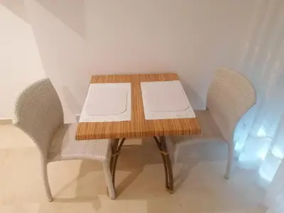 a wooden table with two chairs and a table with twoopens at Apartamento playa Las Arenas in Valencia