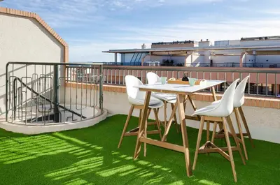 a patio with a table and chairs on a roof at ApartUP Patacona Attic I in Valencia