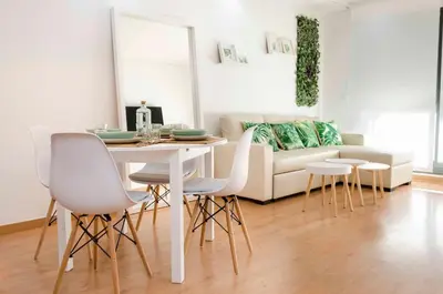 a living room with a table and chairs and a couch at ApartUP Patacona Attic I in Valencia