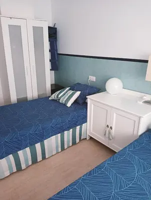 a bedroom with two beds and a white sink and a bed at Apartamentos Playa de Moncofa in Moncófar