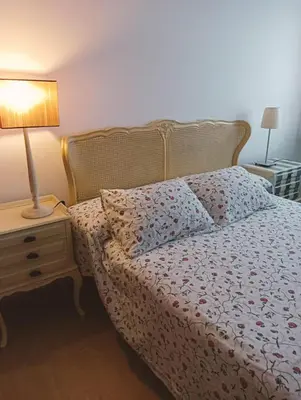 a bedroom with a bed and a lamp on a night stand at Apartamentos Playa de Moncofa in Moncófar