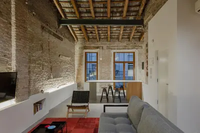a living room with brick walls and a couch at Invalencia - Musico 3 Turia Gardens in Valencia