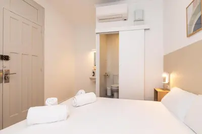 a bedroom with a white bed with two towels on it at Pensión Alicante by Moontels in Valencia