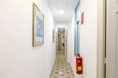 a corridor with a fire extinguisher in a hallway at Pensión Alicante by Moontels in Valencia