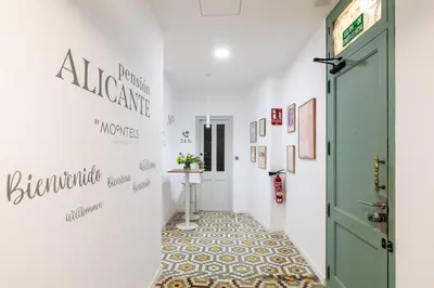 a hallway with a green door and a tile floor at Pensión Alicante by Moontels in Valencia