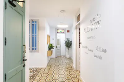 a hallway with a green door and a tile floor at Pensión Alicante by Moontels in Valencia