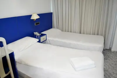 a hotel room with two beds and a lamp at Hotel Vila-real Azul in Villareal