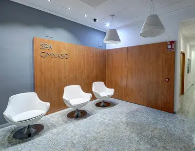 two white chairs in a room with a wall at Hotel Vila-real Palace in Villareal