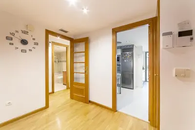 a room with a clock on the wall and a door at Apartamento en Av. de Francia y C.Artes y Ciencias in Valencia