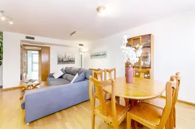 a living room with a table and a blue couch at Apartamento en Av. de Francia y C.Artes y Ciencias in Valencia