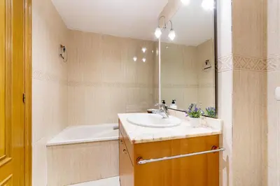 a bathroom with a sink and a tub and a mirror at Apartamento en Av. de Francia y C.Artes y Ciencias in Valencia