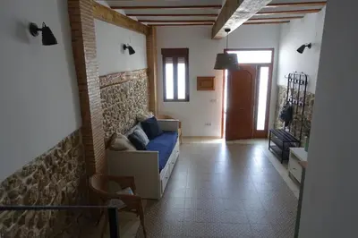 a living room with a couch and a brick wall at Casa La Abuela in Chulilla