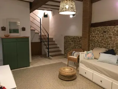 a living room with a couch and a staircase at Casa La Abuela in Chulilla