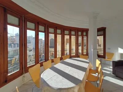 a dining room with a table and chairs and windows at Entre la Estación y el Ayuntamiento in Valencia