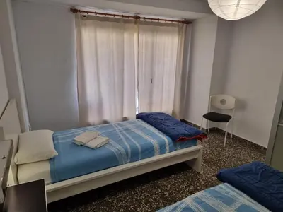 a bedroom with a bed with blue sheets and a window at Apartamento Ruzafa in Valencia
