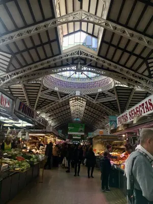 a market with people walking through a market with fruits and vegetables at City Center Atico 360 in Valencia