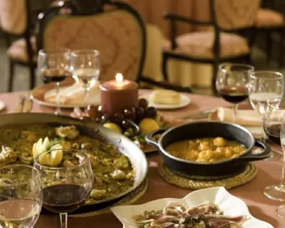 a table with a plate of food and wine glasses at Casa Quiquet in Beniparrell