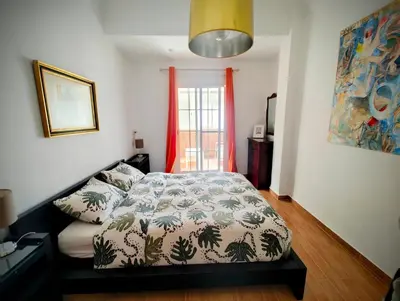 a bedroom with a bed and a green chair at City of Arts in Valencia