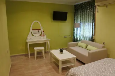 a living room with a couch and a mirror at Hostal Andrés in El Saler