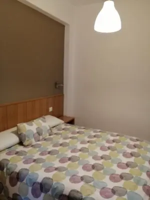 a bedroom with a bed with a colorful comforter at Hostal Andrés in El Saler