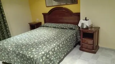 a bedroom with a bed and a nightstand with a bed sidx sidx at Hostal Andrés in El Saler