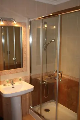 a bathroom with a glass shower and a sink at Hostal Andrés in El Saler