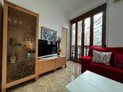 a living room with a red couch and a table at Russafa Codrut in Valencia