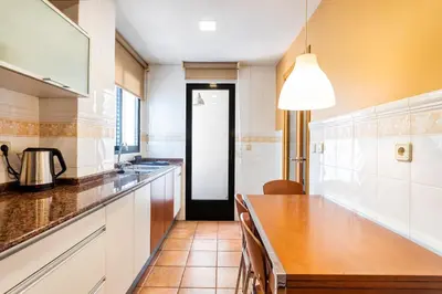 a kitchen with white cabinets and a wooden counter top at Exclusive Museum in Valencia