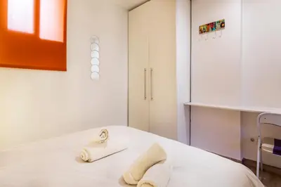a white bedroom with towels on a bed at APARTAMENTO DE ENSUEÑO in Valencia