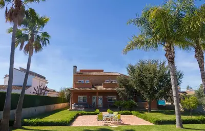 a house with palm trees in front of it at Casa Torre del Virrey in La Eliana