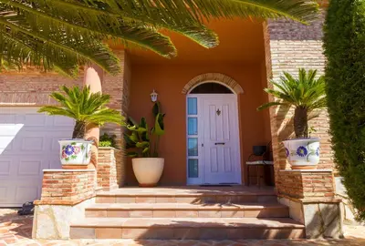 a front door of a house with palm trees at Casa Torre del Virrey in La Eliana