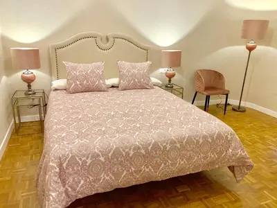 a bedroom with a bed and two lamps and a chair at Hi Valencia Canovas in Valencia
