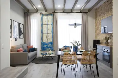 a kitchen and living room with a table and chairs at SingularStays Parque Central in Valencia