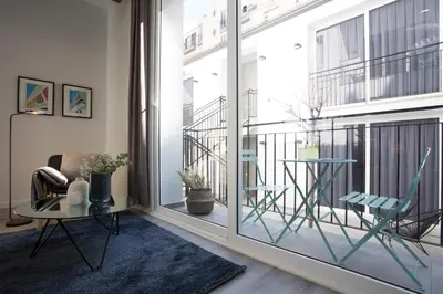 a room with a large window with chairs and a table at SingularStays Parque Central in Valencia