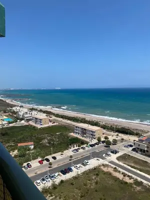 a view of a parking lot next to the beach at Apt. New Holiday Valencia Beach in El Puig