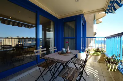 a patio with a table and chairs on a balcony at Apartamento frente al mar in Valencia