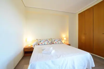 a bedroom with a white bed and two night stands at Apartamento frente al mar in Valencia