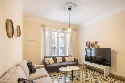 a living room with a couch and a tv at Macflats Ayuntamiento in Valencia