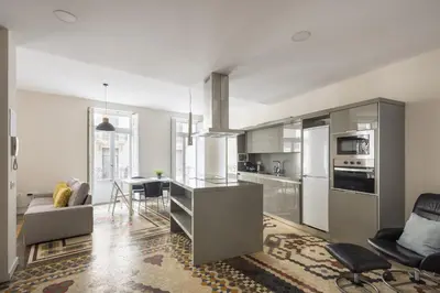 a kitchen with stainless steel appliances and a living room at Macflats Ayuntamiento in Valencia