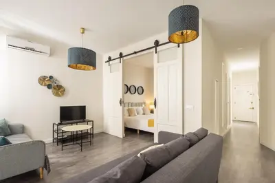 a living room with a couch and a bedroom at Macflats Ayuntamiento in Valencia
