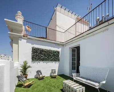 a white house with a patio with chairs and a balcony at Macflats Ayuntamiento in Valencia